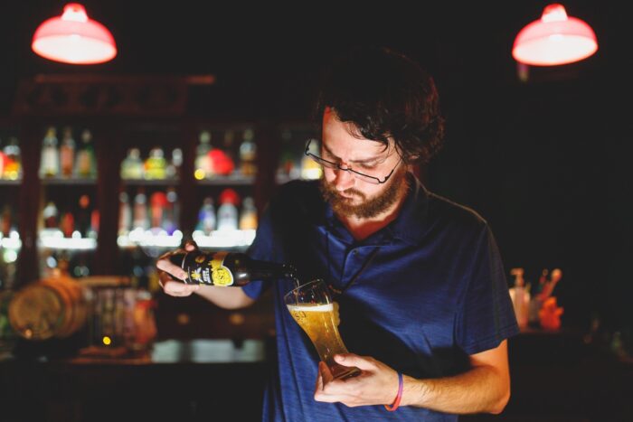 Beerwithjhett pouring a Flying Bees Honey Ale into a beer glass in Ho Chi Minh City, Vietnam